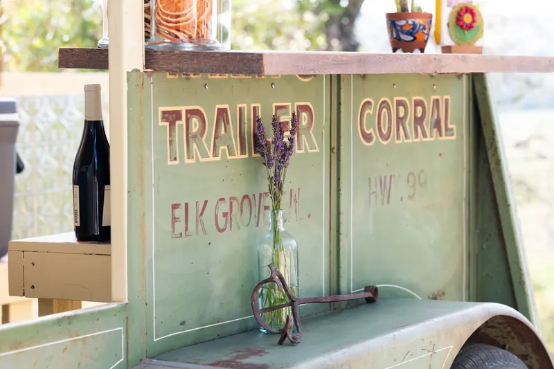 Close-up of the sign-painted Trailer Corral lettering with a lavender bud vase