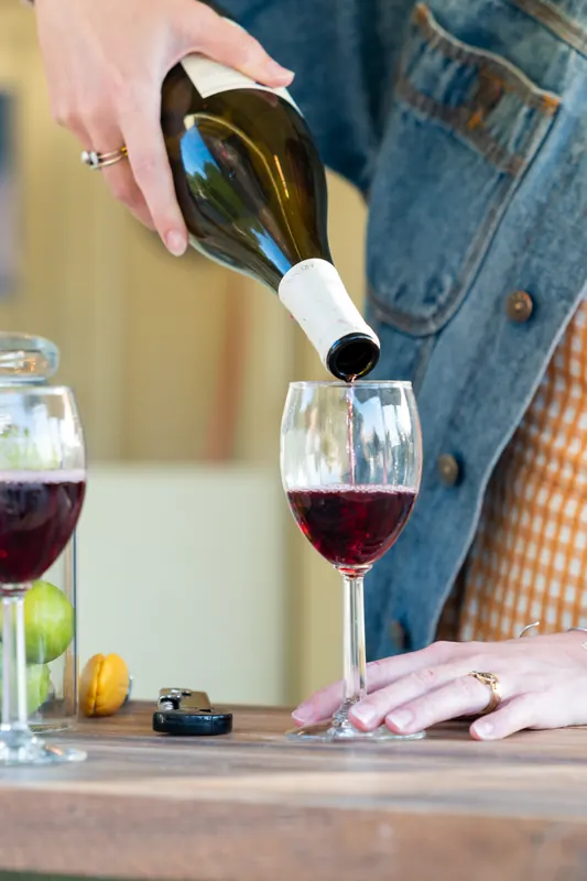 Red wine being poured into a glass on the bar