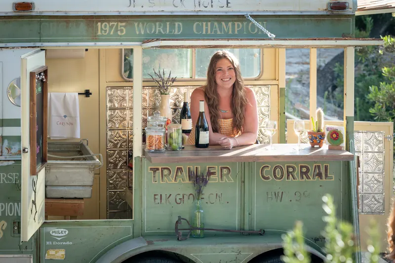 The C-Bar trailer open for service with a smiling bartender behind the bar